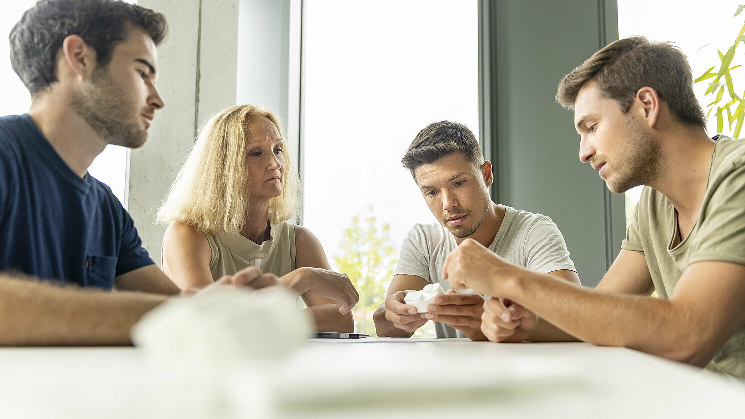 Johannes Sellmaier, Dominik Riediger und Lukas Ernst (von links) beraten sich mit Brigitte Kauer vom start-up center der OTH Regensburg.