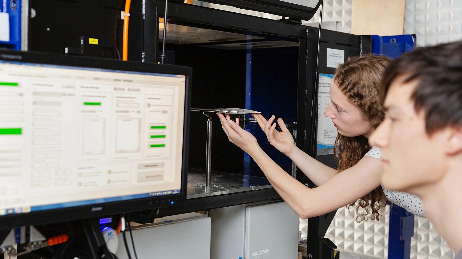 Zwei Studierende bei der aerodynamischen Vermessung eines Flügelprofils am Prüfstand POLAMAX im Labor Windkanal der Fakultät Maschinenbau.