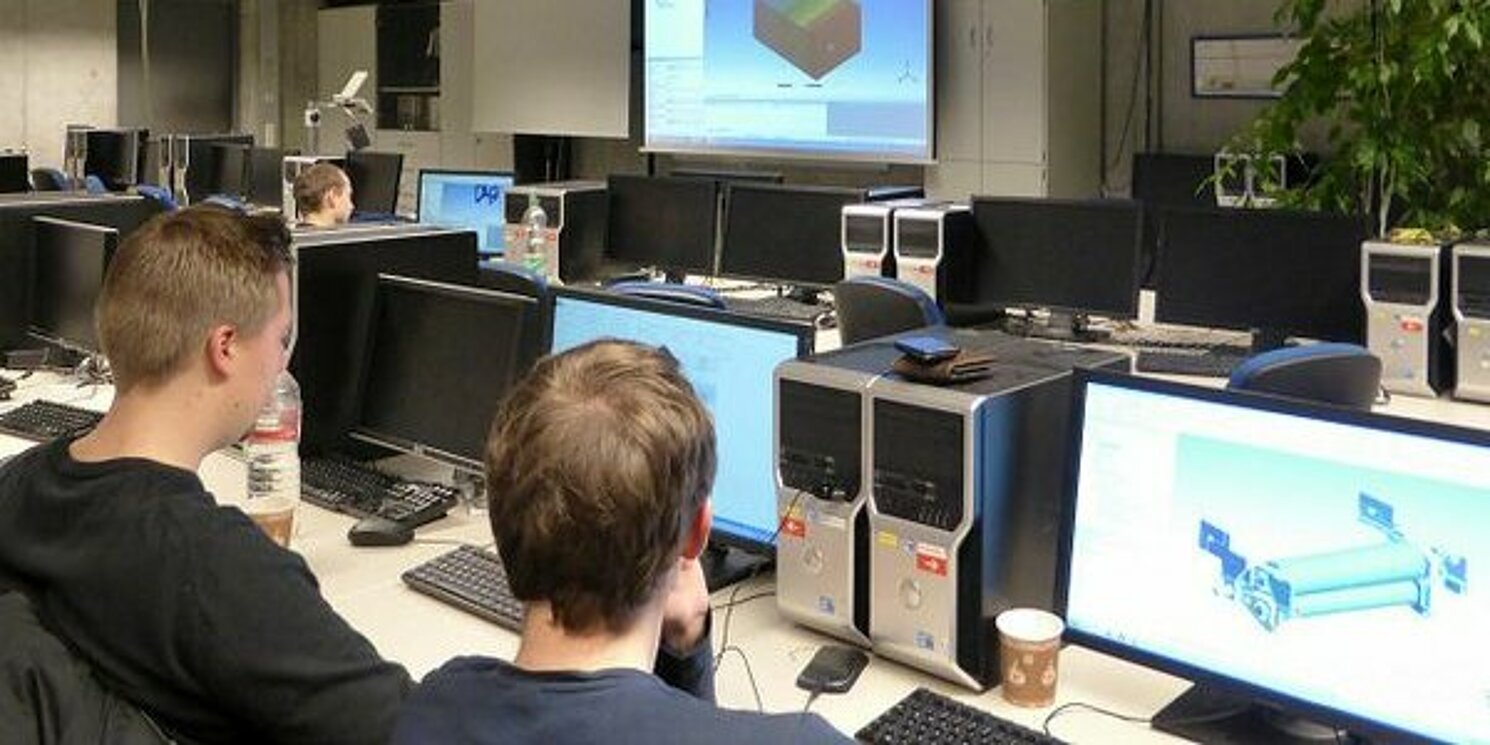 Zwei Studierende arbeiten im Labor vor ihren Bildschirmen.