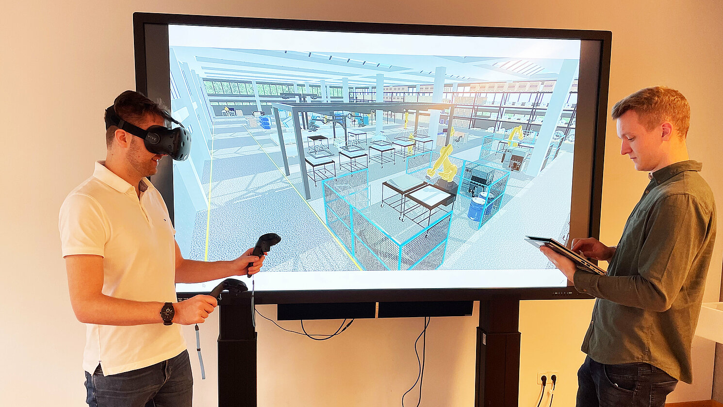 Virtuelle Fabrik: Die wissenschaftlichen Mitarbeiter Lukas Schuhegger (li.) und Tobias Wild diskutieren Produktionsprozesse mithilfe des digitalen Zwillings.