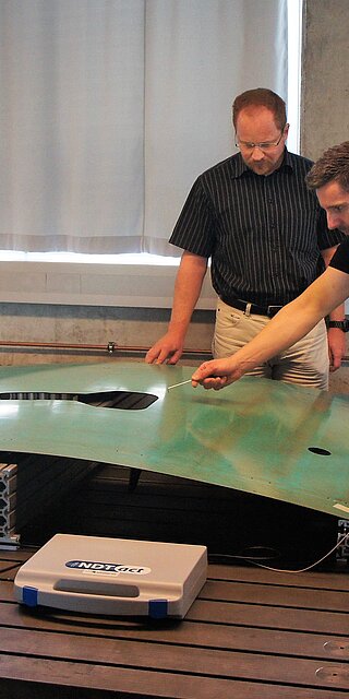 Von links: Prof. Dr.-Ing. Ingo Ehrlich (Leiter Labor für Faserverbundtechnik), Dr. Raino Petricevic (Technischer Geschäftsführer der Firma iNDTact) und Matthias Schlamp (Projektmanager BIRD) am Messaufbau der abschließenden Bauteilversuche im Projekt BIRD