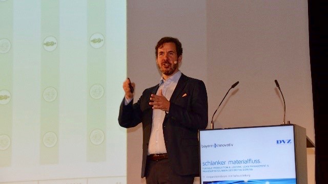 Prof. Stefan Galka von der OTH Regensburg erläutert die Vor- und Nachteile unterschiedlicher Steuerungskonzepte für Routenzüge auf dem 11. Kooperationsforum „Schlanker Materialfluss“ am 14. November 2018 in Regensburg.