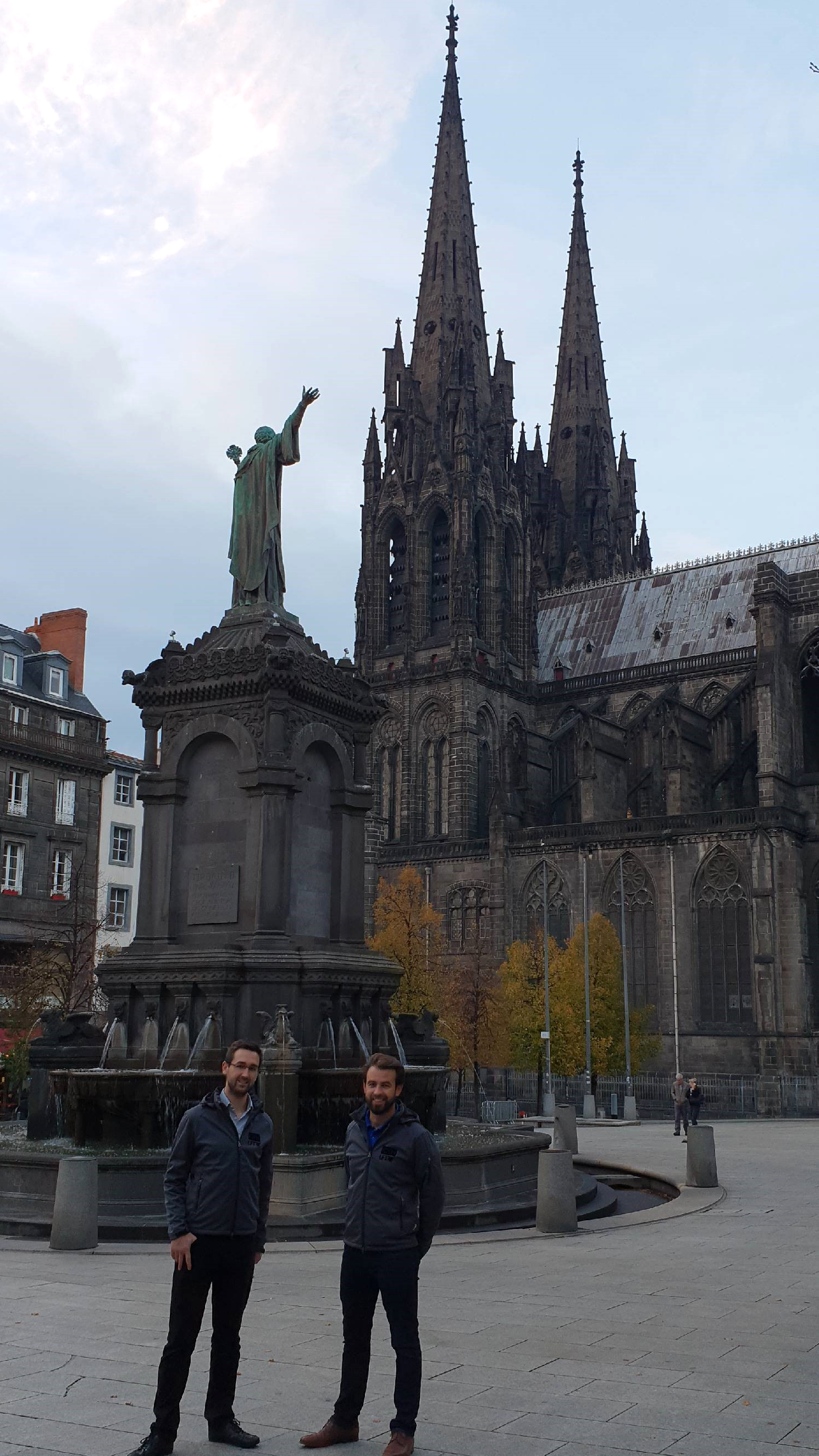 Christian Pongratz und Matthias Schlamp vor dem La Fontaine Urbain II in Clermont-Ferrand. / Christian Pongratz et Matthias Schlamp devant La Fontaine Urbain II et la cathédrale Notre-Dame-de-l’Assomption à Clermont-Ferrand. Foto: Prof. Dr. Ingo Ehrlich